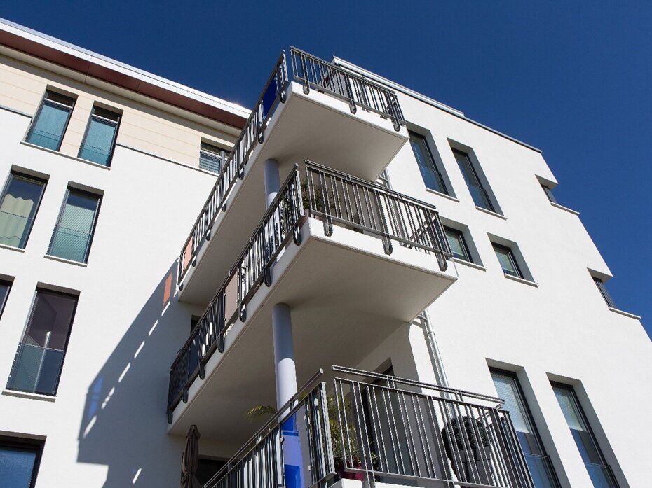 Mehrgeschossiges Wohngebäude mit Balkonen als Beispiel für wirtschaftliches Bauen mit Kalksandstein.