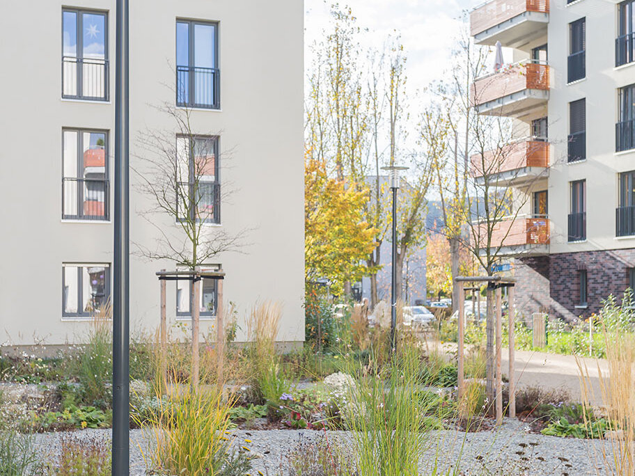 Begrünter Innenbereich des Wohnquartiers in Jena mit Wohngebäuden, Balkonen, Wegen und Pflanzflächen