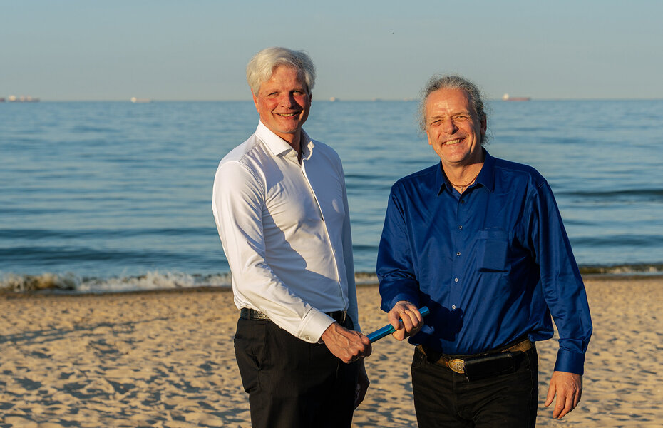 Jan Dietrich Radmacher (l.) übergibt am Strand in Danzig symbolisch den Staffelstab an Frederic Dörlitz, seinen Nachfolger als Vorstandsvorsitzender des Bundesverbands Kalksandsteinindustrie e.V.